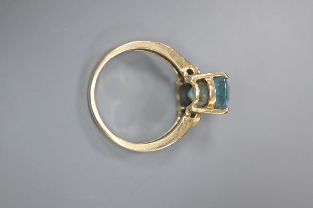 A modern 9ct gold, blue topaz and gem set dress ring, size N, gross 4 grams.